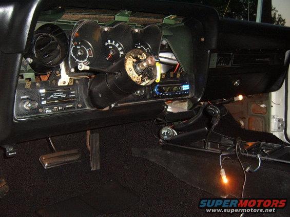 1973 Ford Ranchero interior dashboard with steering column removed, showing gauges, radio, and pedals