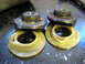 1996 Ford Bronco - Close-up of two automotive suspension spring seats and isolators resting on a work surface.