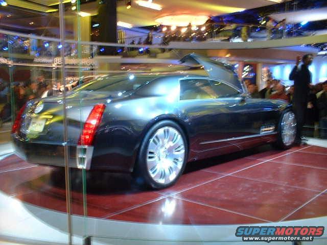 Dark gray Cadillac concept car with gullwing doors open, on display at an auto show