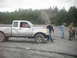 1993 Suzuki Sidekick - Damaged silver pickup truck with a red vehicle in the background and people standing around.