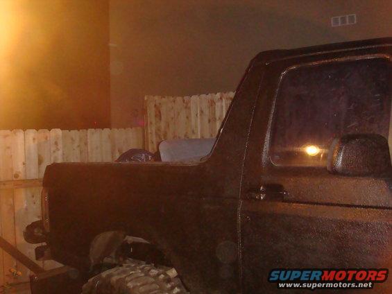 Side view of a black 1992 Ford Bronco parked near a wooden fence