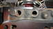 1964 Ford Fairlane - Close-up of an engine part showing casting marks 'DOOF C' and bolt holes, with other engine components visible in the background.
