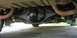 1976 Ford Ranchero - Underside view of a vehicle's rear axle and suspension system, showing the differential and exhaust pipes.