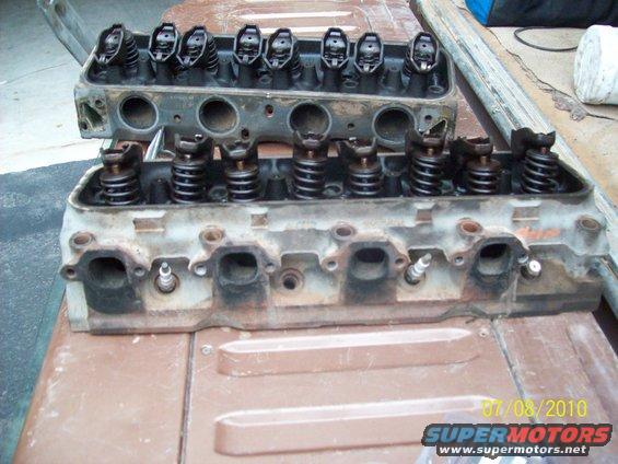 Two engine cylinder heads with valves and springs visible