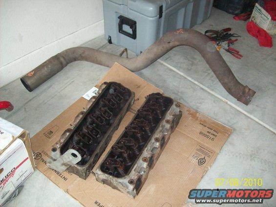 Engine cylinder heads and exhaust pipe on cardboard