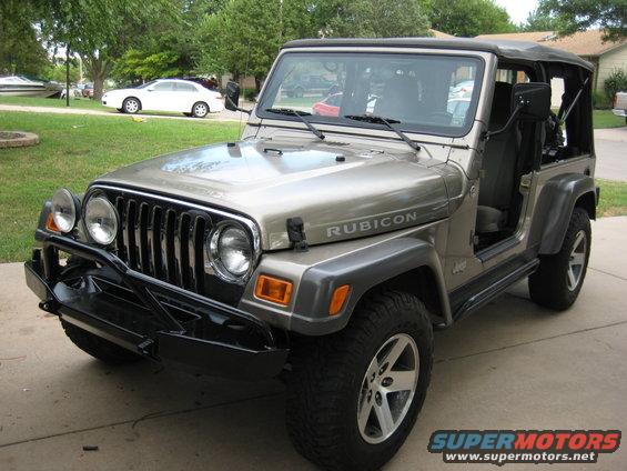 Tan 2005 Jeep Wrangler Rubicon with black aftermarket bumper and soft top