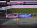 1992 Ford Mustang - A drag strip scene with advertising banners visible on a chain-link fence.
