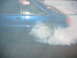1992 Ford Mustang - A blue 1992 Ford Mustang performs a burnout, kicking up a large cloud of smoke.