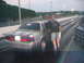 1992 Ford Mustang - A person leans on a 1992 Ford Mustang at a drag strip, ready for a race.