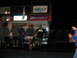 1992 Ford Mustang - Spectators gather at a nighttime racing event, with prominent signage for Hoosier Racing Tire and Speedtech.