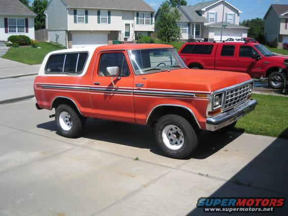 Orange and white 1979 Ford Bronco parked in driveway