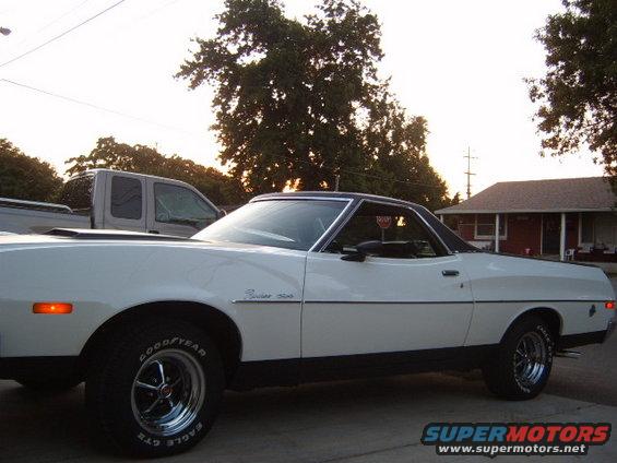 White 1973 Ford Ranchero with black trim and vinyl roof, seen from the side