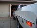 1973 Ford Ranchero - Rear three-quarter view of a white 1973 Ford Ranchero parked in front of a garage.