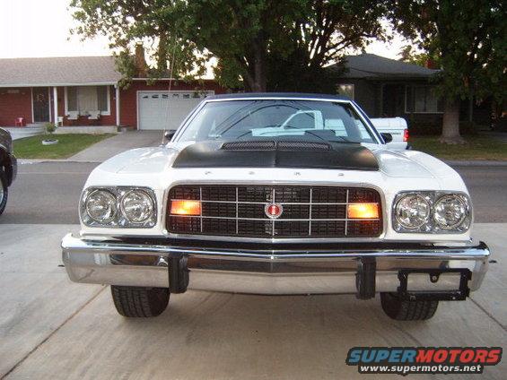 front view of a white pickup truck with a black hood scoop
