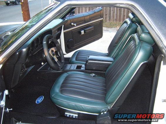 1973 Ford Ranchero interior with green and black seats and a Ford logo on the carpet
