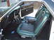1973 Ford Ranchero - The interior of a 1973 Ford Ranchero features green and black vinyl seats, a black dashboard, and a Ford logo on the floor mat.