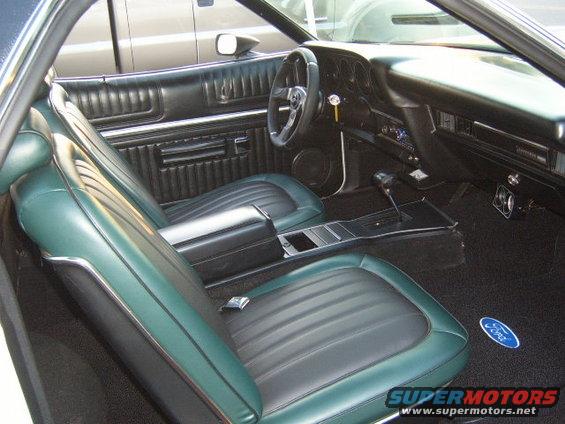Green and black interior of a 1973 Ford Ranchero with a Ford logo on the carpet