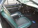 1973 Ford Ranchero - The interior of a 1973 Ford Ranchero features green and black vinyl seats, a center console, and a Ford logo on the floor mat.