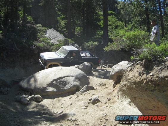 Dark blue pickup truck on rocky off-road trail
