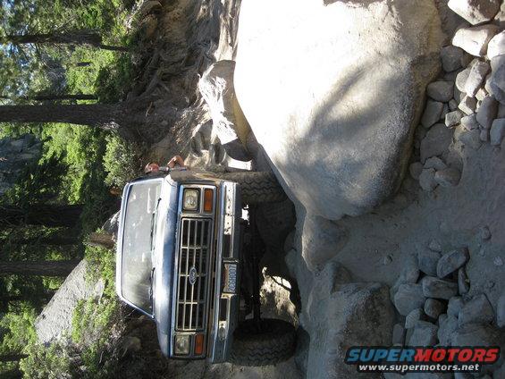 Ford Bronco navigating a rocky trail, front grille visible. License plate reads PCCGH007