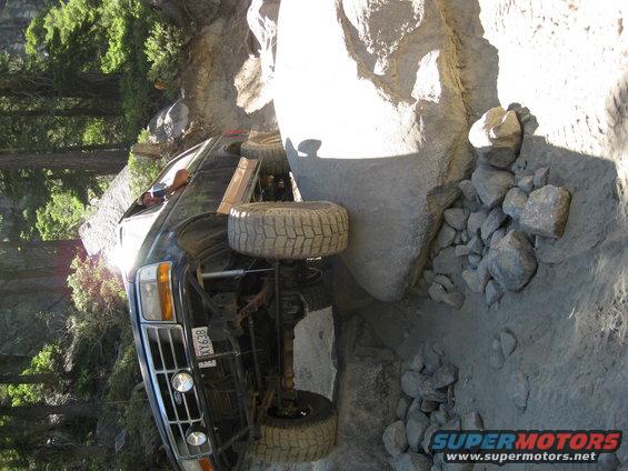 Black SUV stuck on rocks, front grille visible