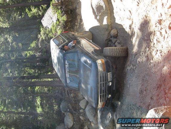 Dark blue 1987 Ford Bronco off-roading on a rocky trail