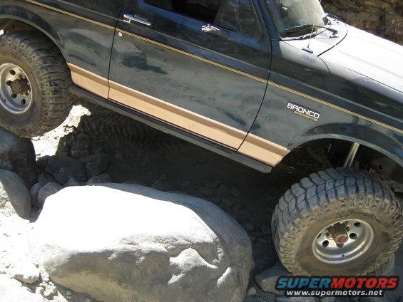 1986 Ford Bronco climbing over rocks on a trail
