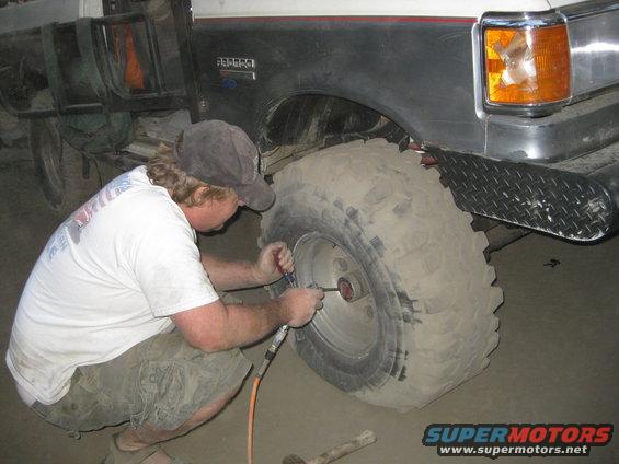 1986 Ford Bronco side view, man airing up tire