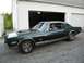 1968 Mercury Cougar - A man sits behind the wheel of a classic coupe parked in front of a garage.