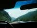 1968 Mercury Cougar - Driving through a scenic mountain pass, with other cars and trucks on the highway ahead.