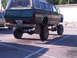 1986 Ford Bronco - This lifted Datsun pickup truck has a camper shell and a custom bumper. The license plate is visible.