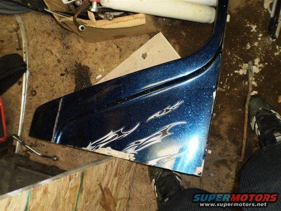 Blue fender with flame decals, glitter paint, and damage on the edge