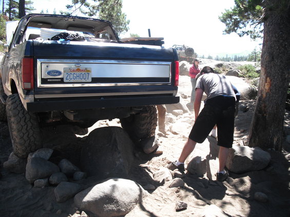 1987 Ford Bronco rear view on rocky terrain with people nearby