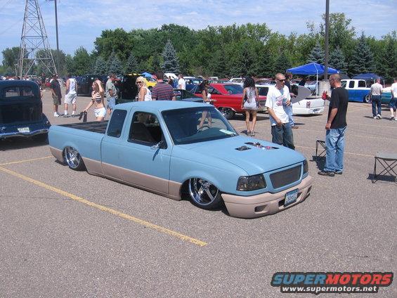 Light blue and tan pickup truck with lowered suspension and custom wheels