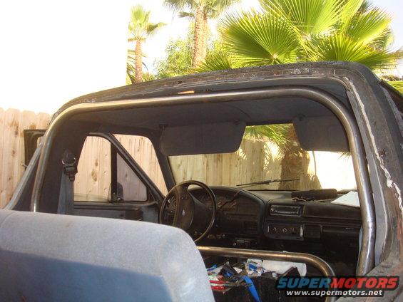 Interior view of a 1992 Ford Bronco showing dashboard, steering wheel, and roll cage