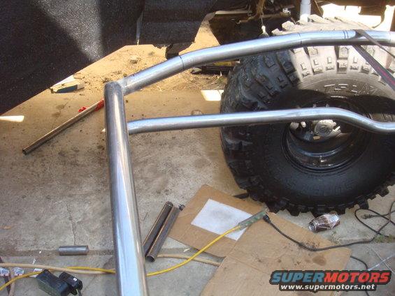 Roll cage tubing installation near a large off-road tire