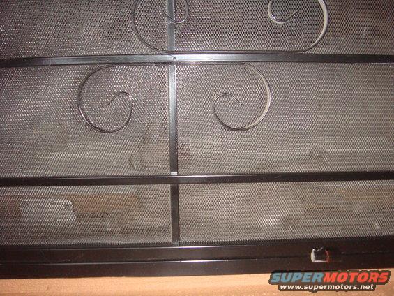 Black metal screen with decorative scrollwork and a Supermotors.net logo at the bottom right