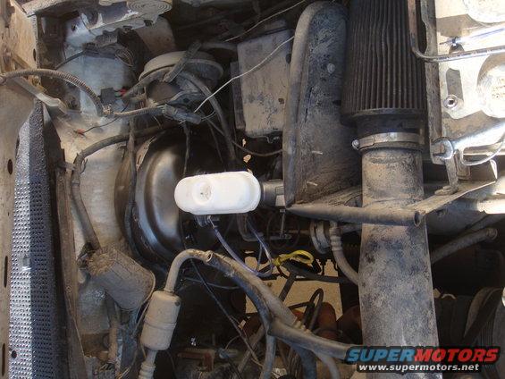 Engine bay showing brake booster, master cylinder, air filter, and various hoses and wires