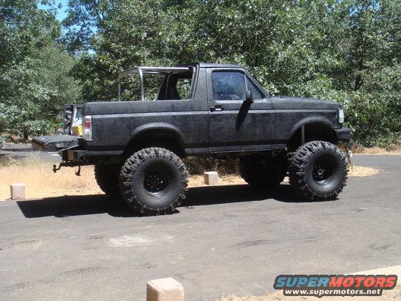 Lifted black Ford Bronco with large tires parked on asphalt