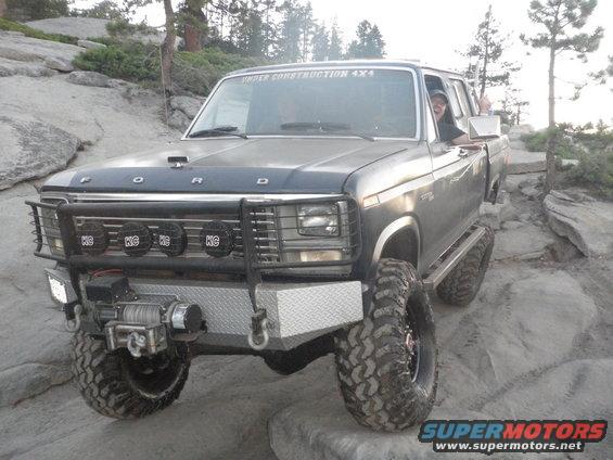 Gray Ford Bronco off-roading on rocks, with a winch and brush guard