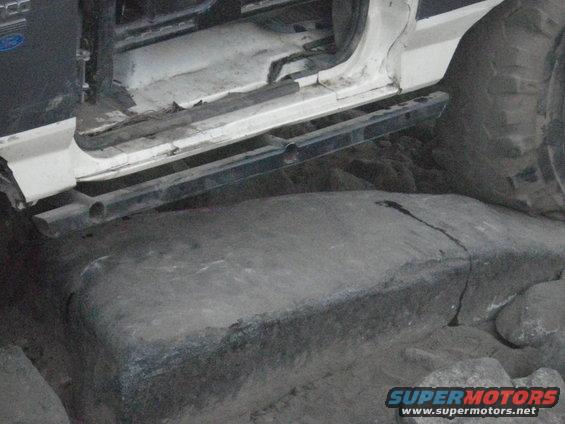 1991 Ford Bronco door open, showing running board and tire on rocks