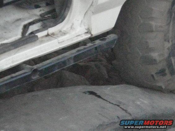 Close-up of rocky ground and a vehicle's running board