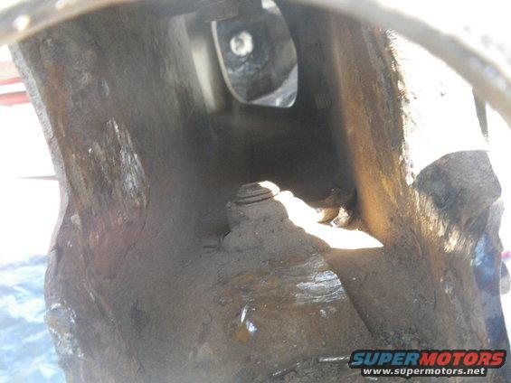 Close-up of heavily rusted, hollow metal structure with a bolt visible inside