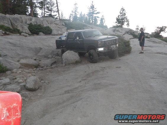 Black pickup truck navigating rocky terrain