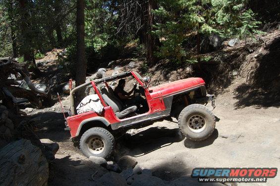 Red 1993 Jeep Wrangler navigating a rocky off-road trail