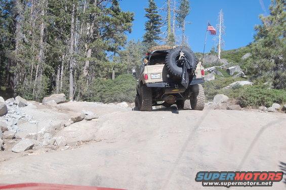 1993 Jeep Wrangler on a rocky off-road trail, spare tire mounted on the back