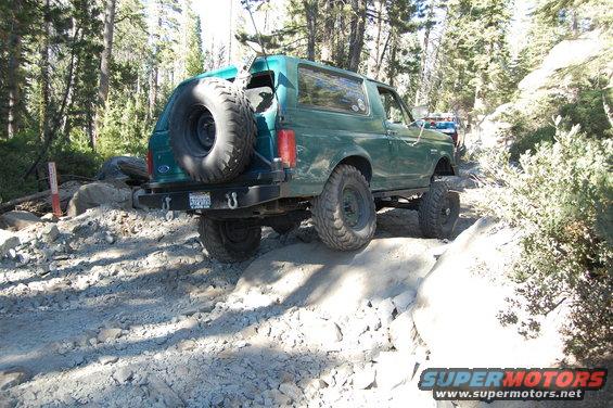 Green 1993 Ford Bronco rear view on rocky trail