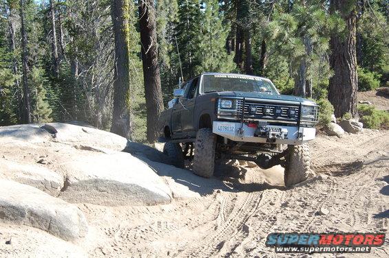 Ford F-Series pickup truck on a rocky trail, front bumper has a winch and license plate 4D78032