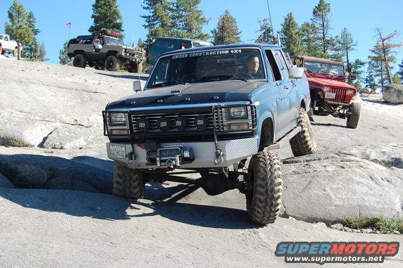 Blue pickup truck with custom bumper and winch, off-roading