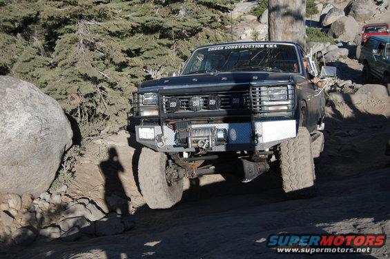 Black off-road truck with winch and custom bumper on rocky terrain